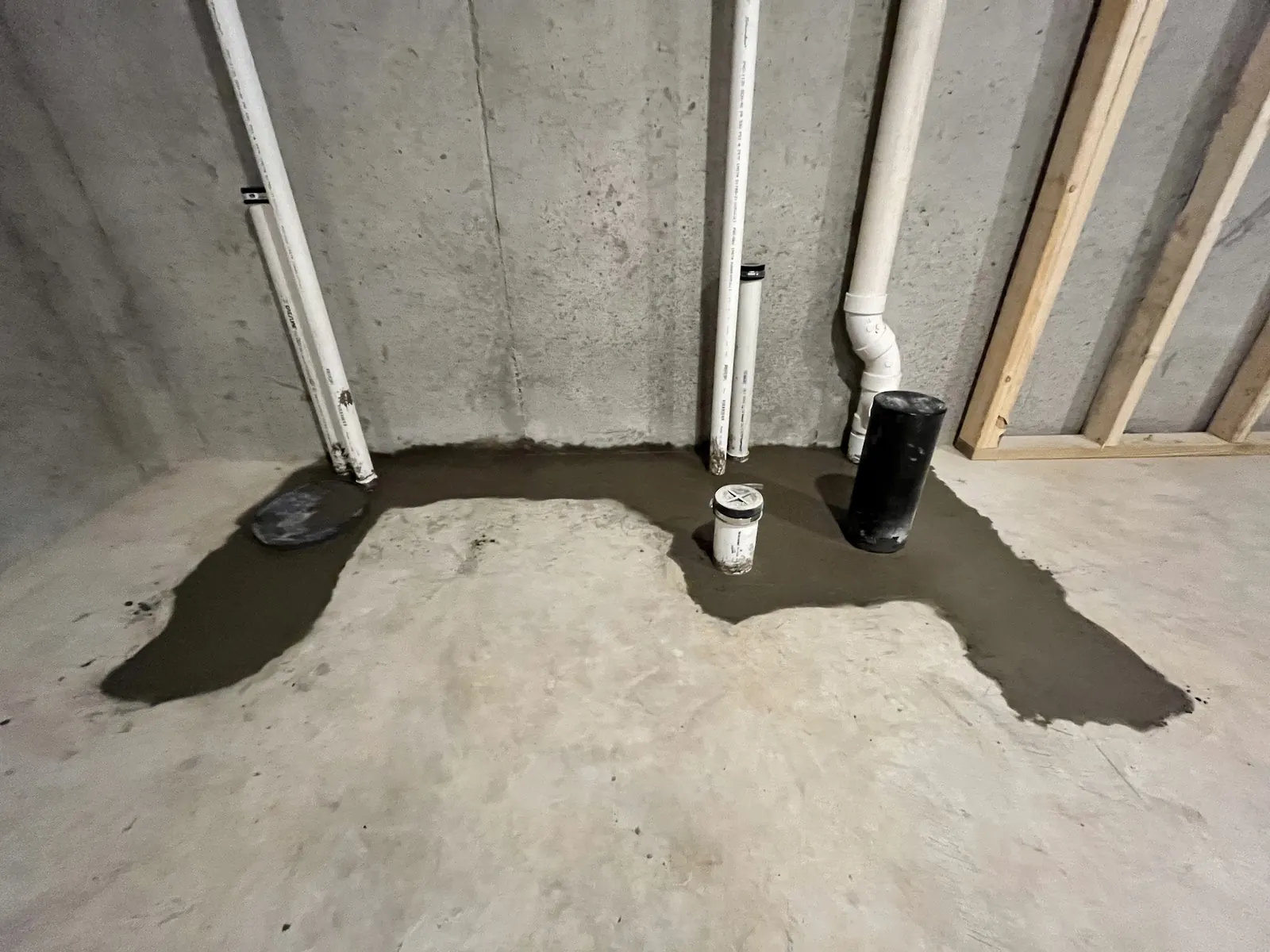 Fresh concrete patch in a basement floor after a drain repair under the slab