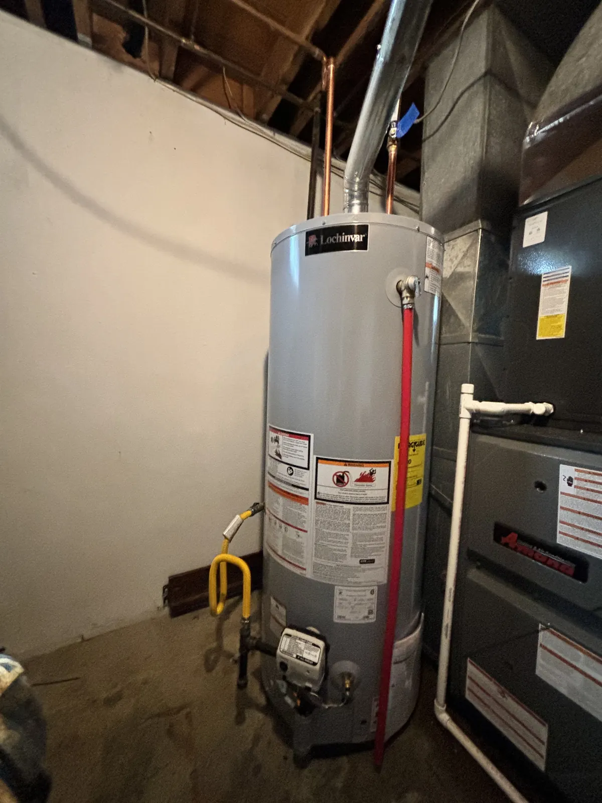 New gas water heater installed next to a furnace
