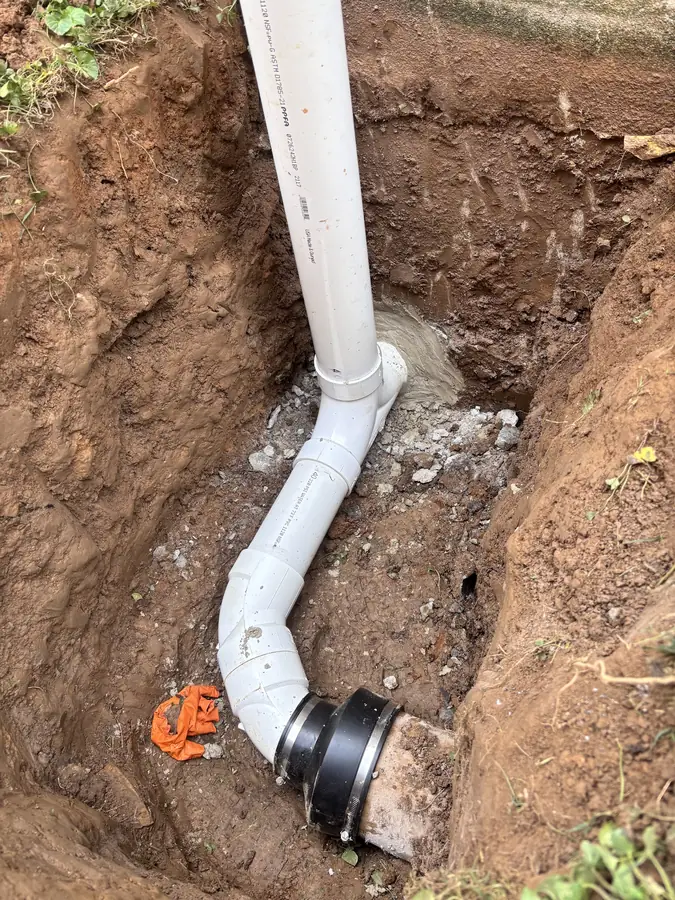 New PVC line joined to the old pipe with a coupling in an open trench