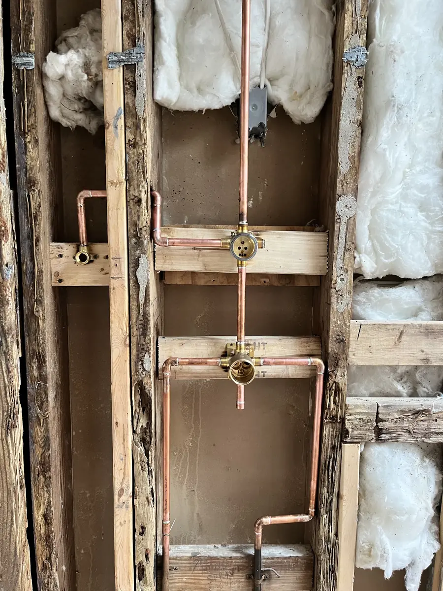 Shower valve and copper water lines roughed in inside an open wall