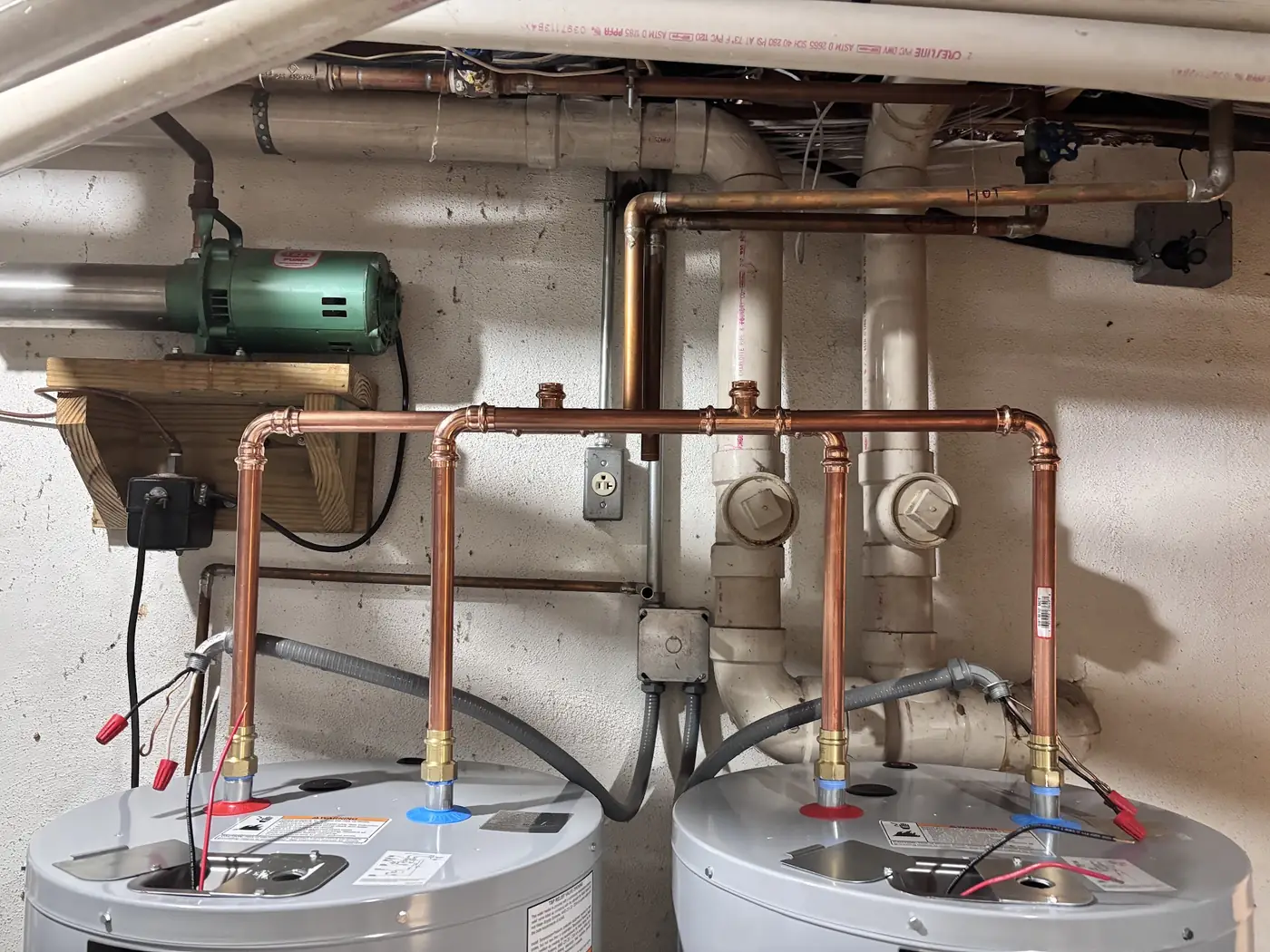New copper water lines above two electric water heaters